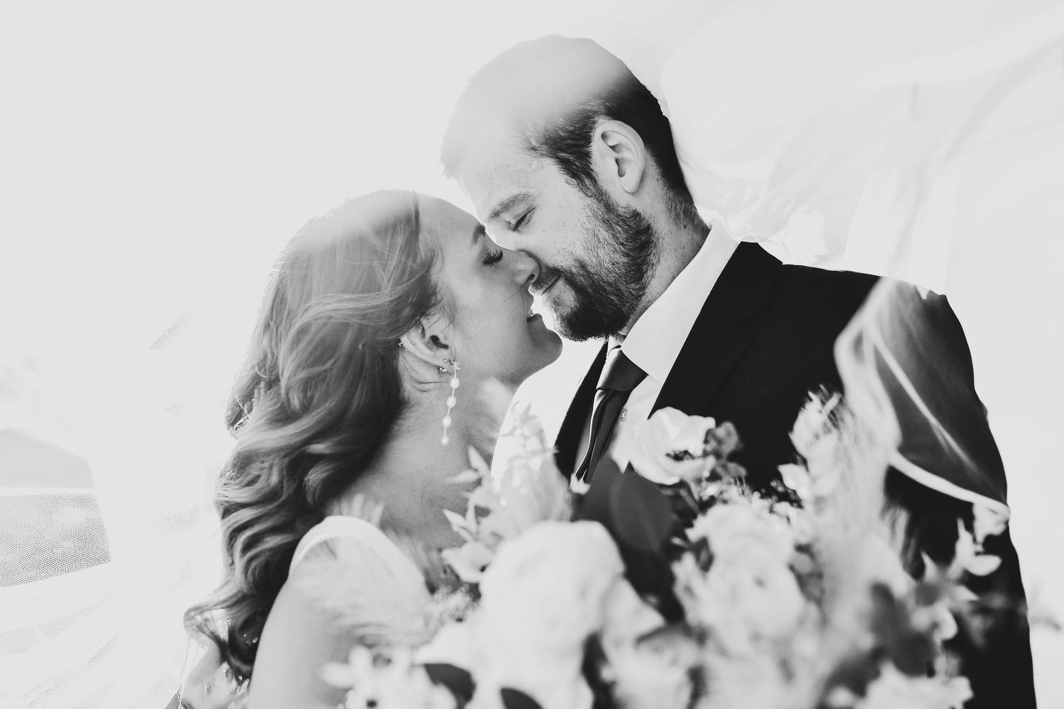 black and white wedding portrait captured at the madelyn wedding venue in collinsville of the bride and groom kissing under the bride's veil