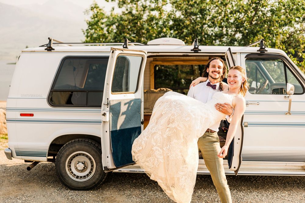 A joyful moment with a vintage white van during a wedding photoshoot.