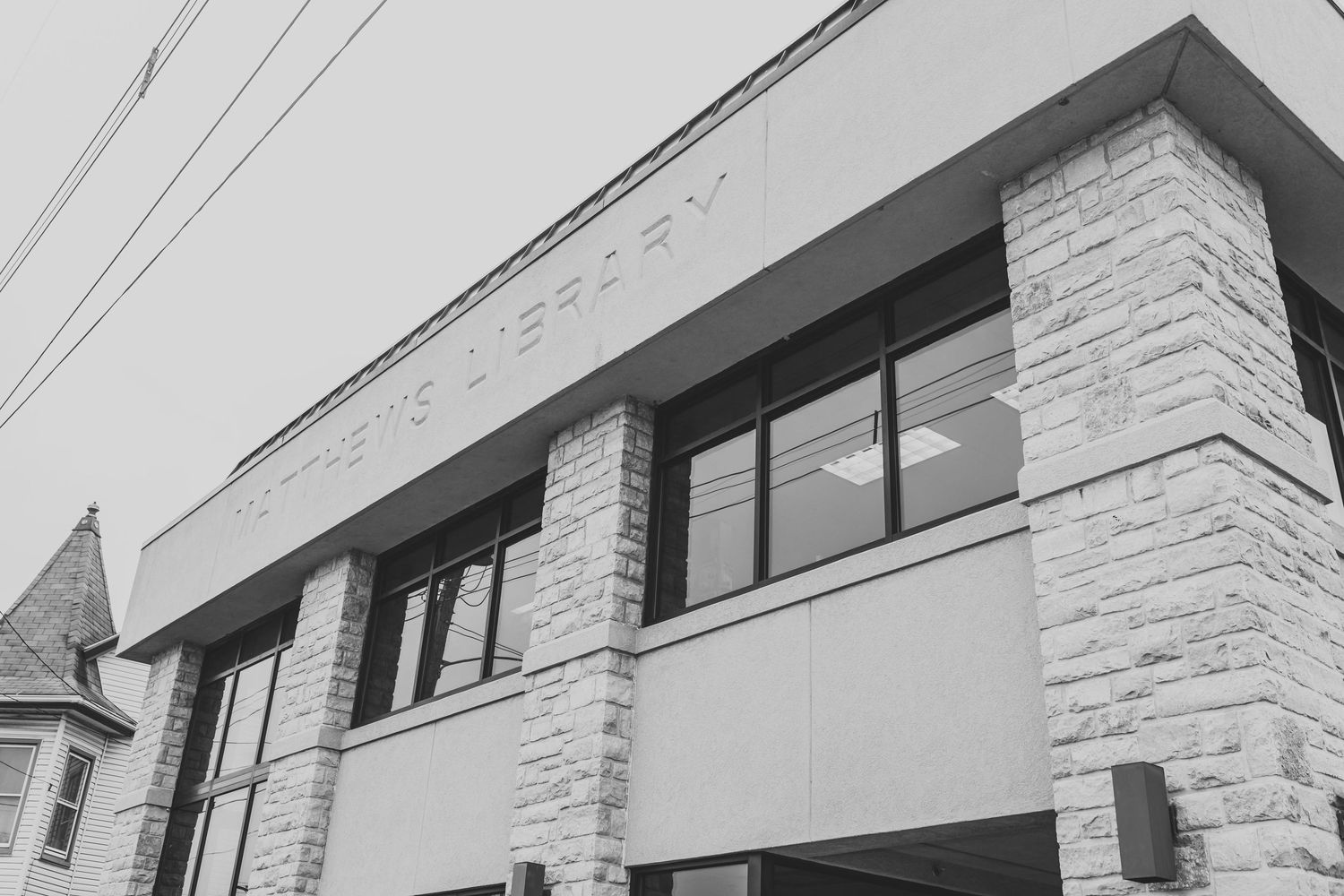 Black and white architectural detail of the Matthews Library building with stone facade and large windows in Fredericksburg, Pennsylvania