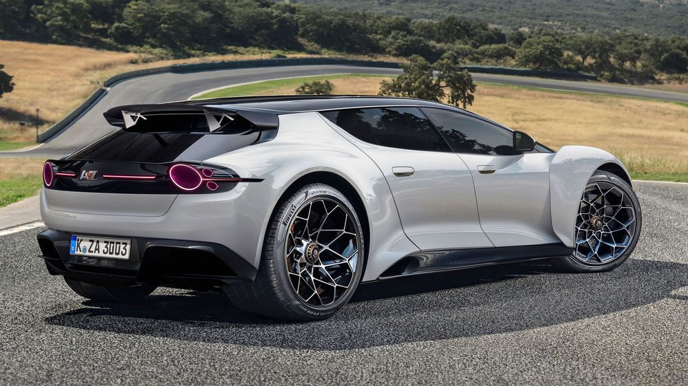 A sleek silver Lotus Emira sports car with black wheels and accents photographed on a winding mountain road.