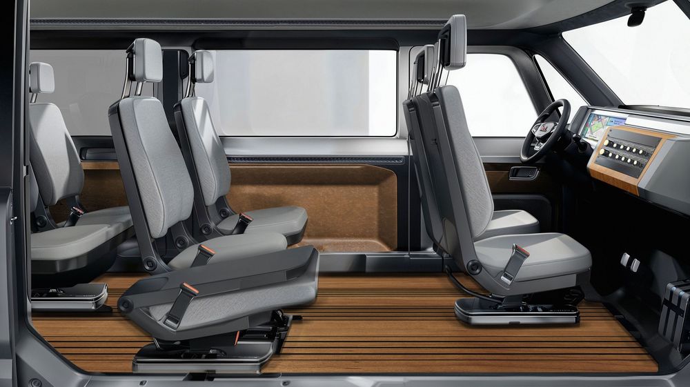 Interior view of a modern van showing gray passenger seats and wooden floor panels in a sleek cabin design.