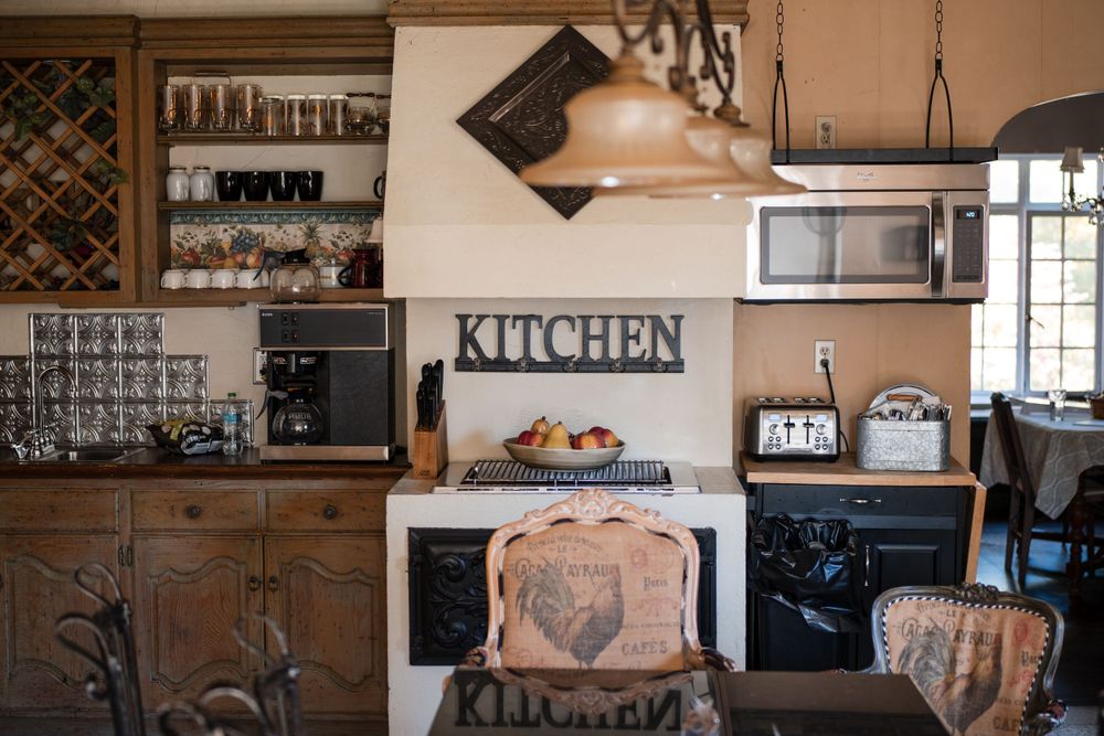 Rustic kitchen interior with wooden cabinets, wine rack and vintage decor.