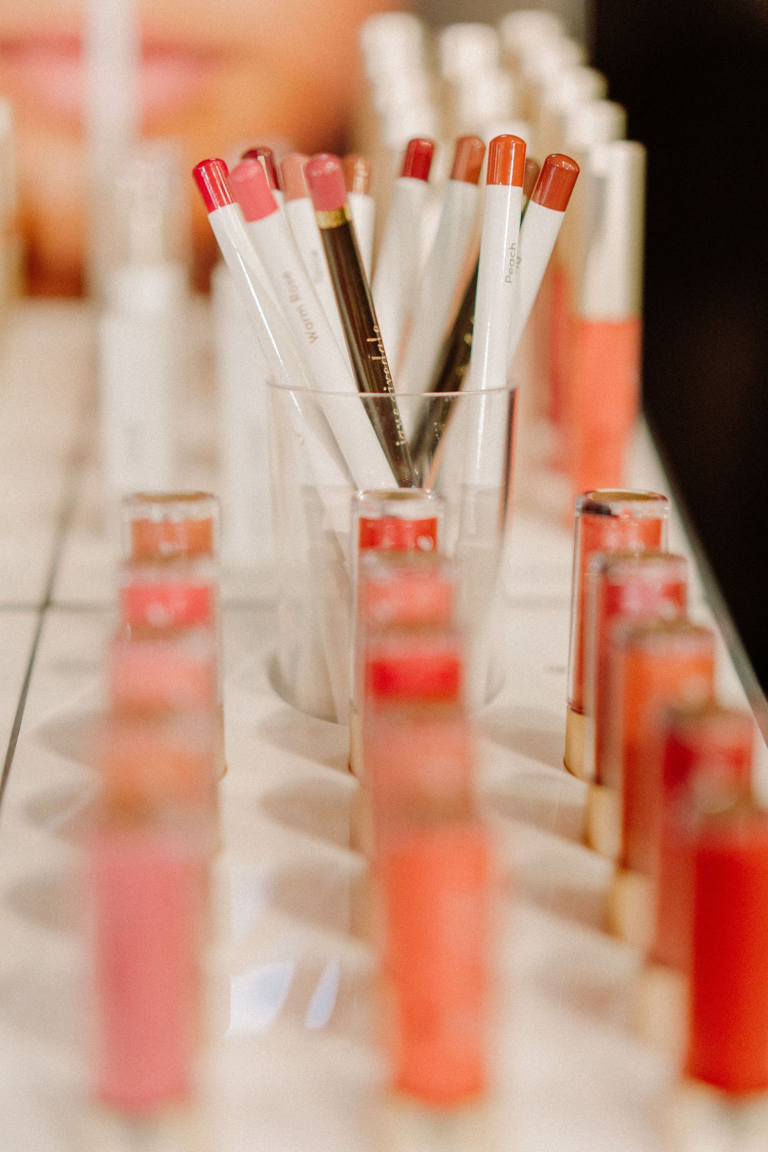Glass tubes filled with pink and coral-colored liquid samples arranged in rows.