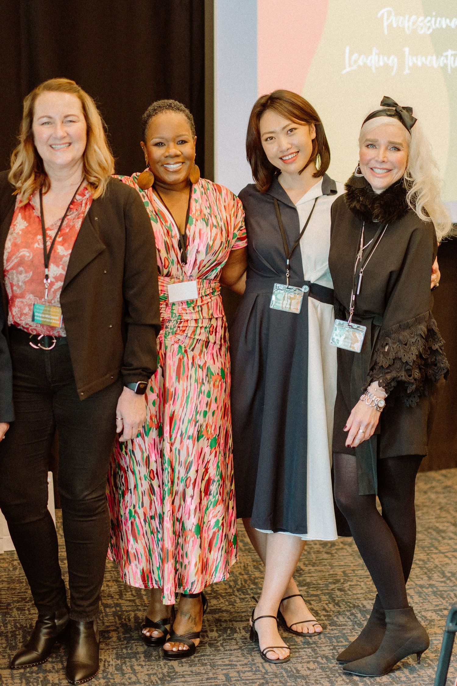 Group photo of four women at a professional conference wearing name badges.