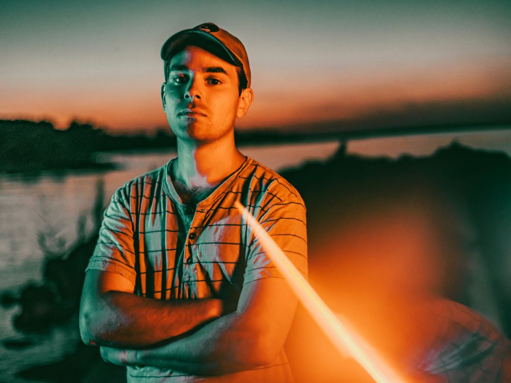 Dramatic sunset portrait with orange and teal color grading.