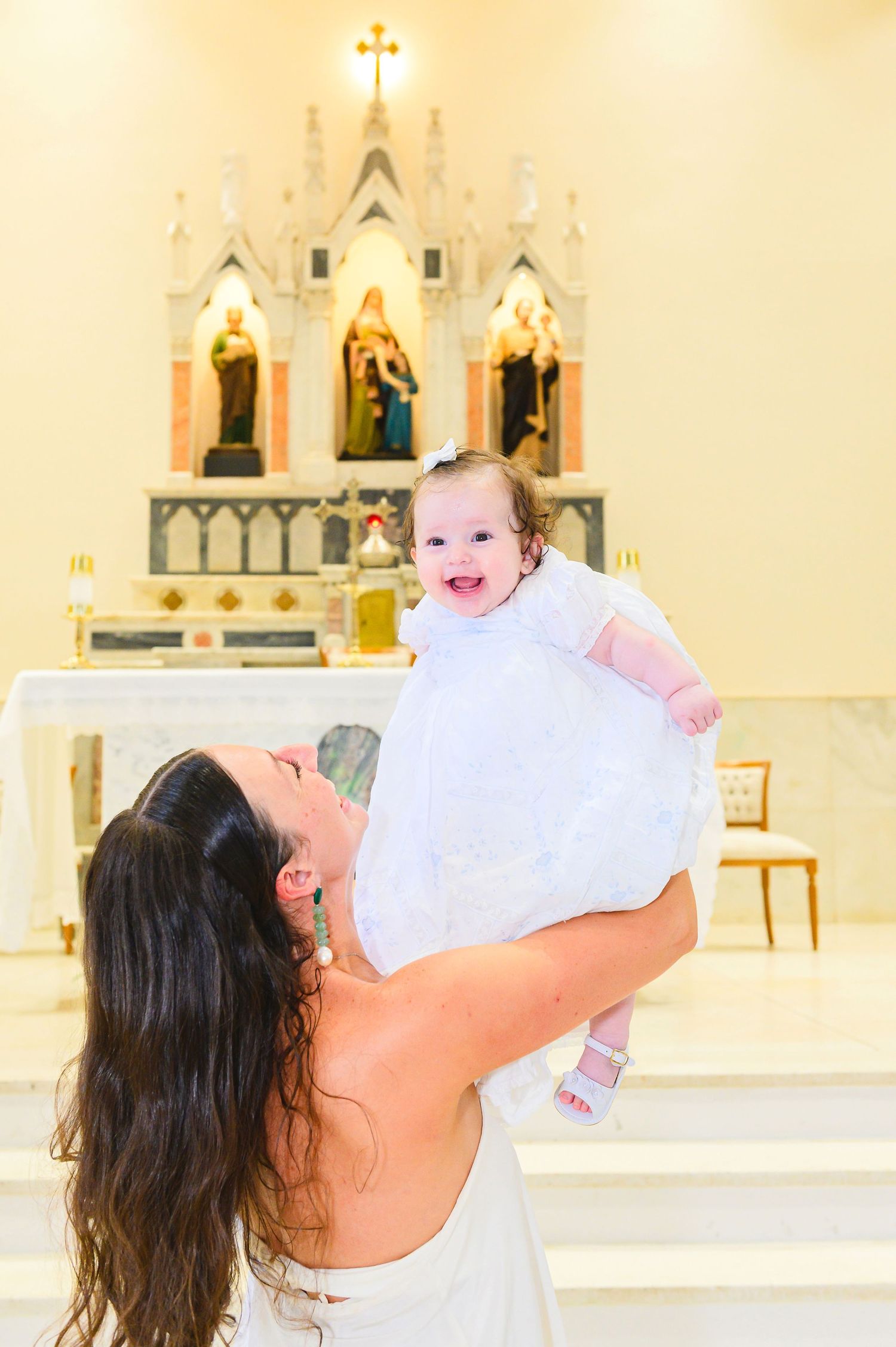 A joyful moment inside a church with decorative altar and religious statues visible in the background.