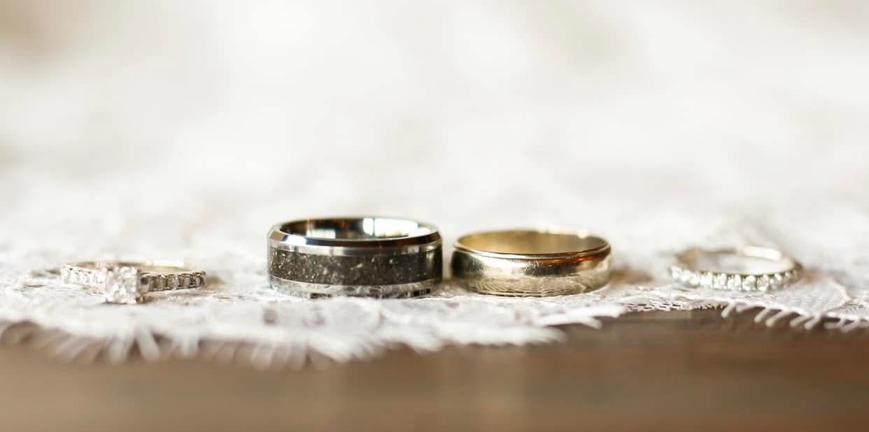 Two wedding rings resting on delicate white lace, capturing an intimate moment with selective focus and soft lighting.