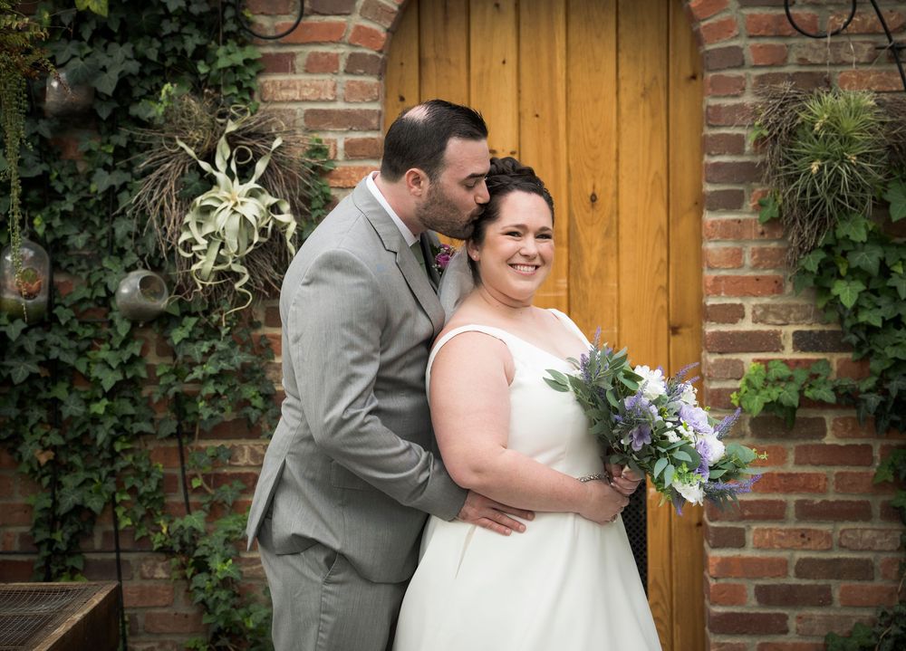 Beautiful brick and wooden doorway entrance decorated for a rustic outdoor wedding ceremony.