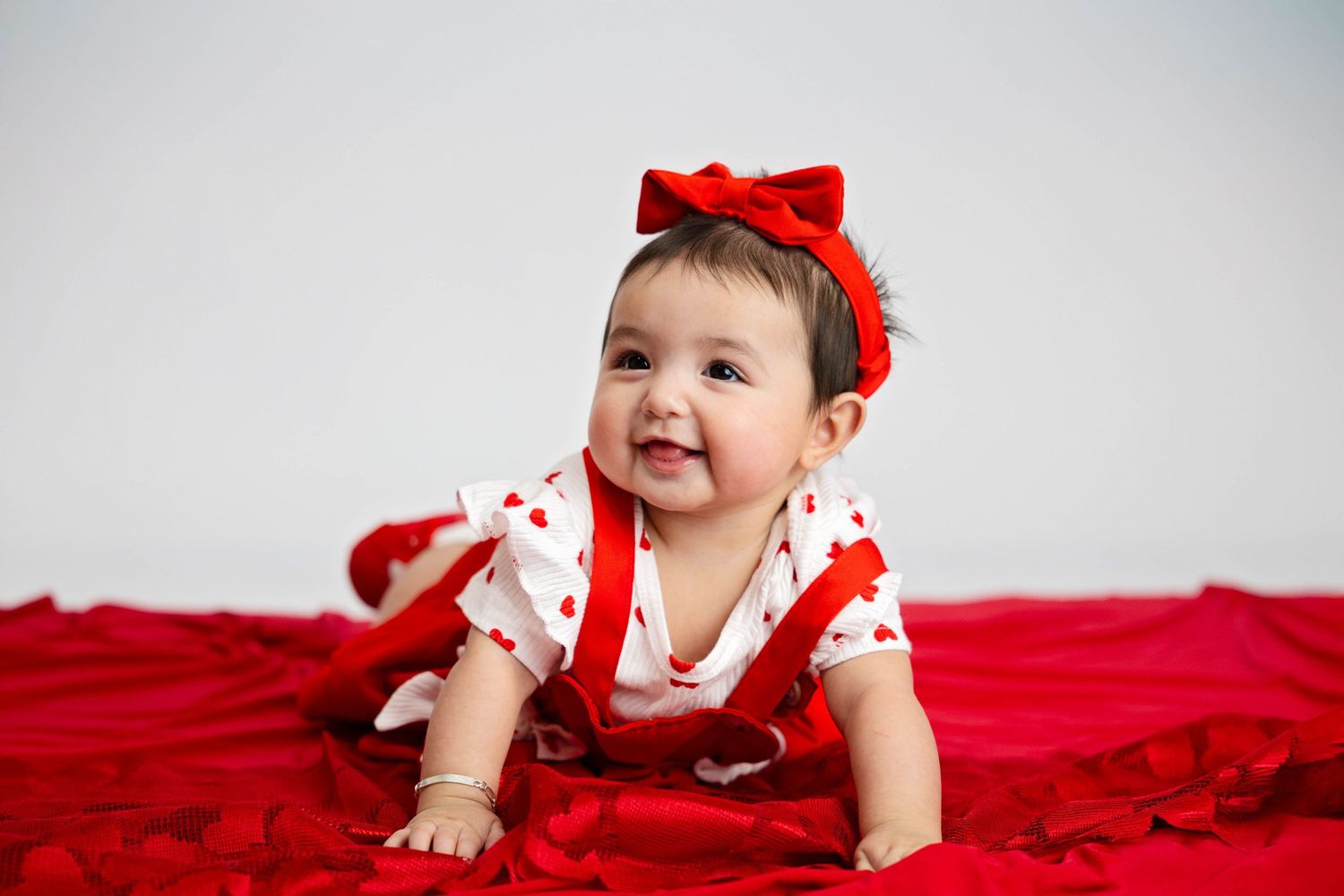 Valentines baby photography. Red bow. Baby girl. Baby on red blanket. Newborn and maternity photographer. Roswell, Artesia, Carlsbad, NM.