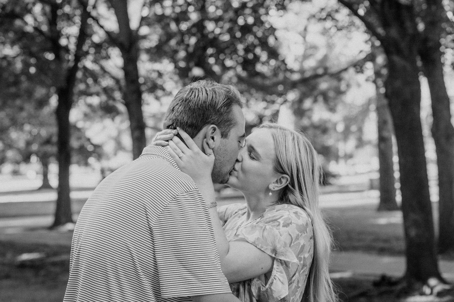 A romantic black and white portrait captured in a park setting.