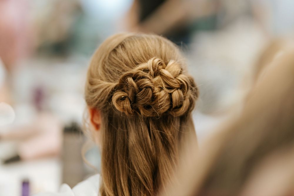 An elegant braided updo hairstyle styled in a soft crown pattern photographed from behind.