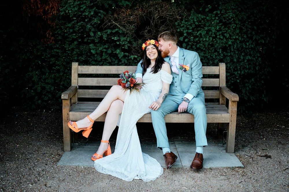 A romantic photoshoot sequence with a couple sitting and embracing on a wooden bench surrounded by greenery.