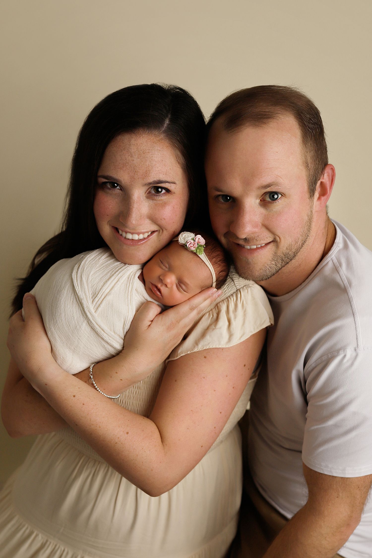 Utah newborn photos. A sequence of romantic couple portraits showing playful intimate moments in matching white and cream colored outfits.