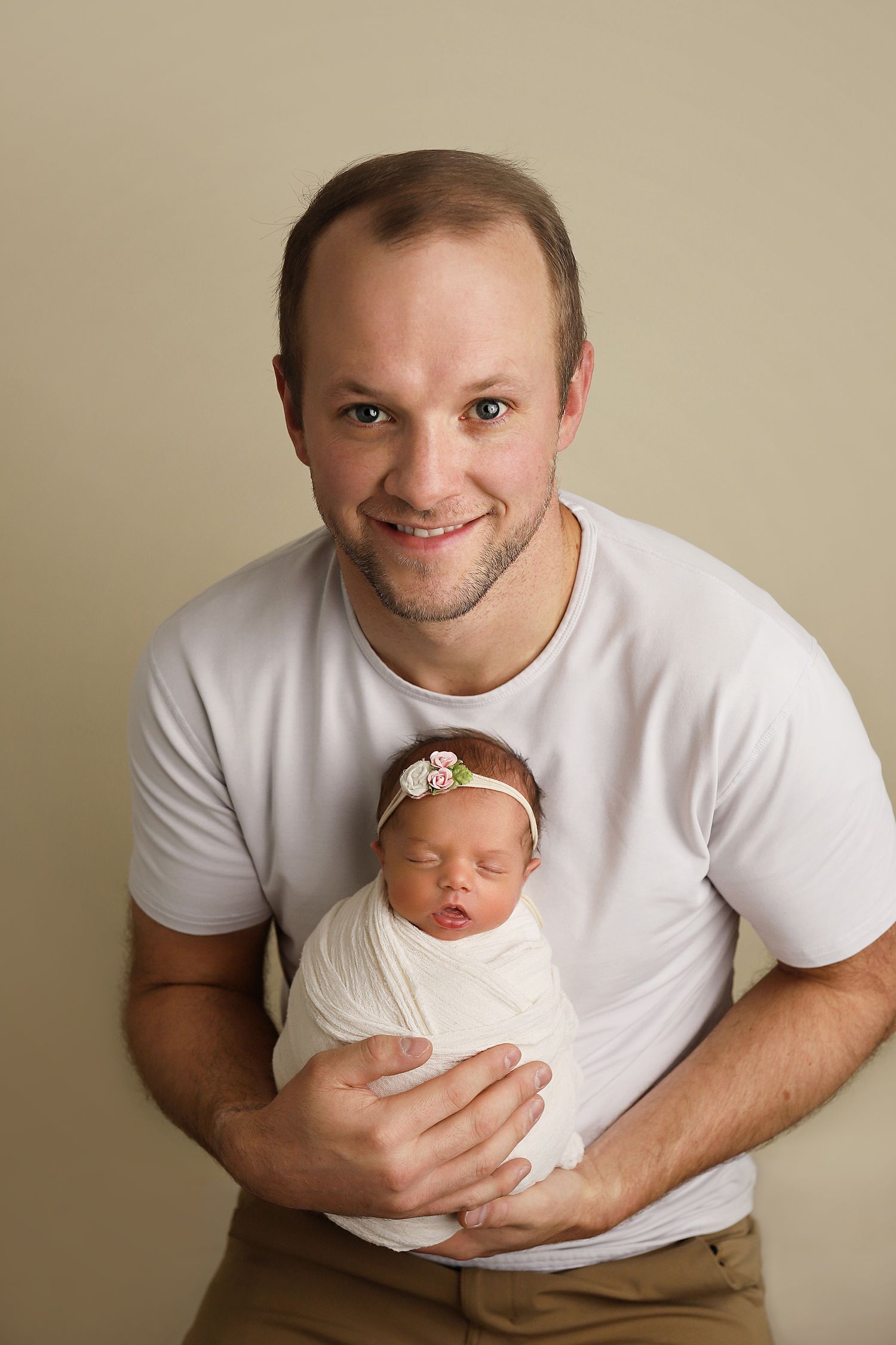 A heartwarming progression of images shows a parent holding and bonding with their sleeping newborn baby.