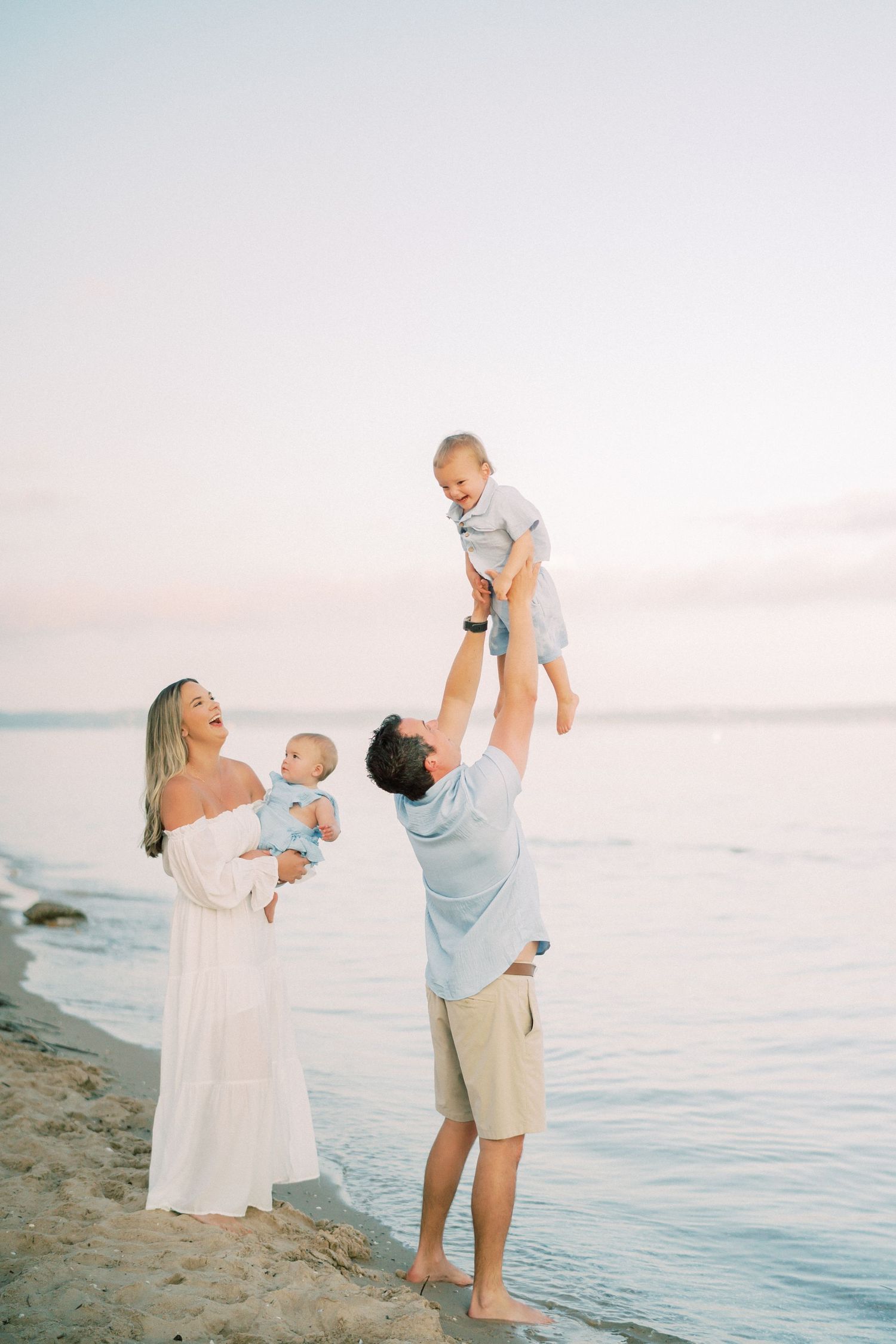 Scenic beach sunset scene with family enjoying the water's edge on a warm summer evening.