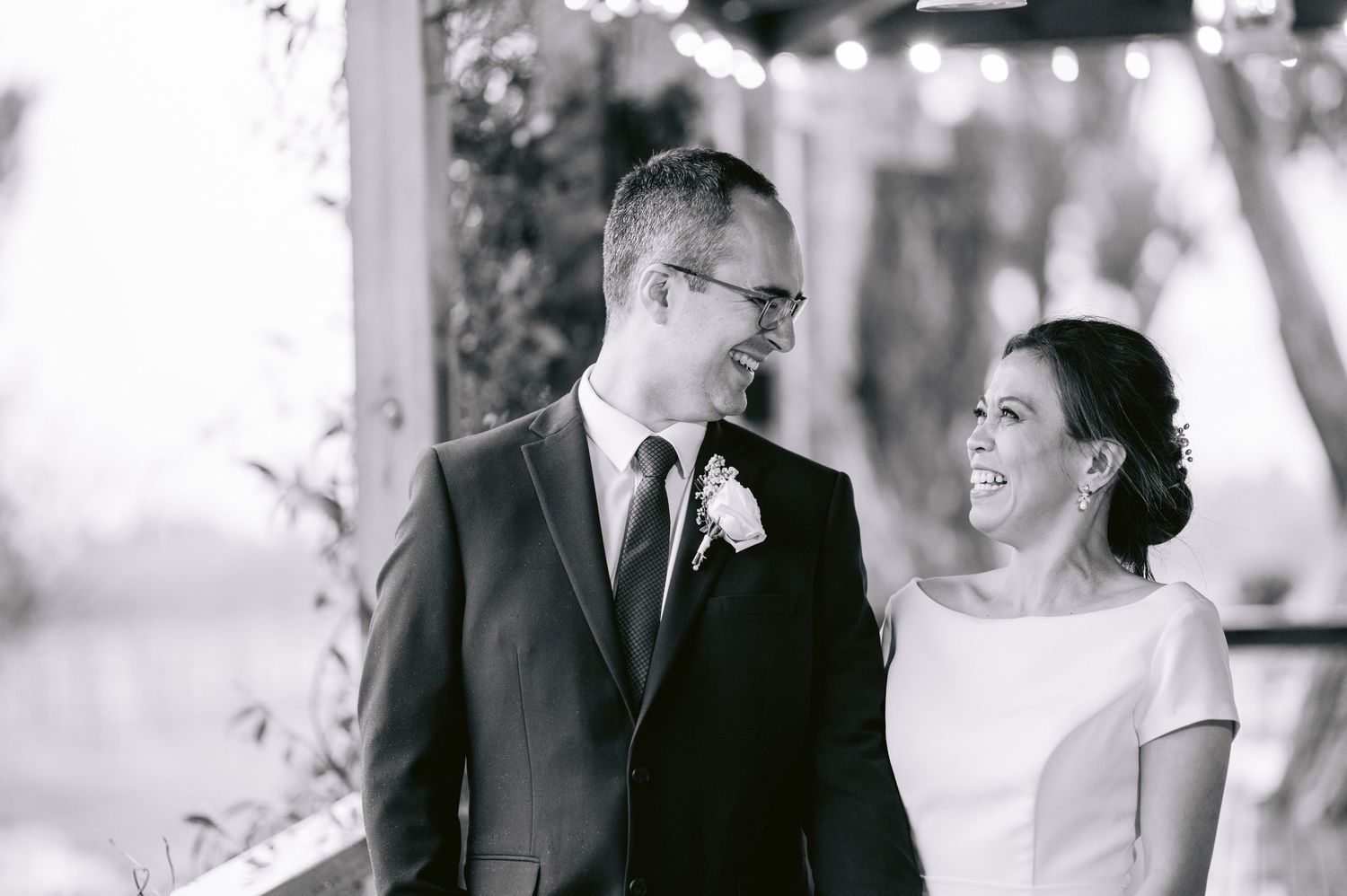 A series of four black and white wedding photographs showing romantic moments between a bride and groom outdoors.