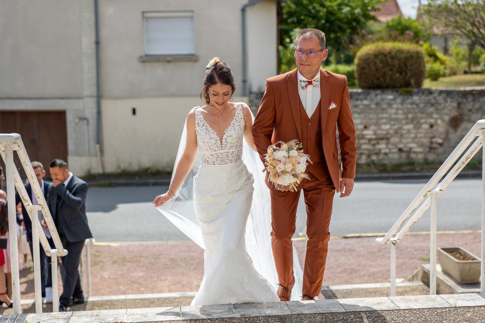 A couple descends white stone steps after their wedding ceremony.