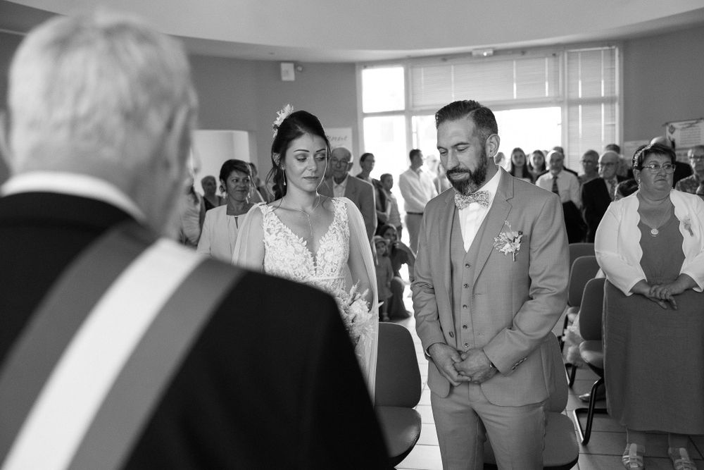 Black and white photo of a wedding ceremony in progress indoors.