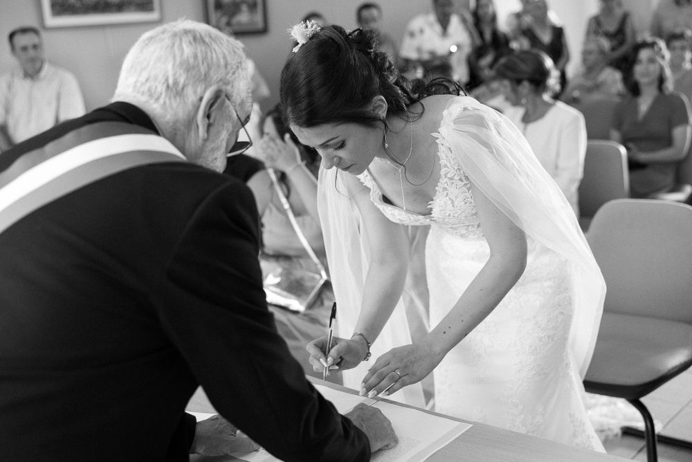 Black and white candid moment during wedding document signing ceremony.