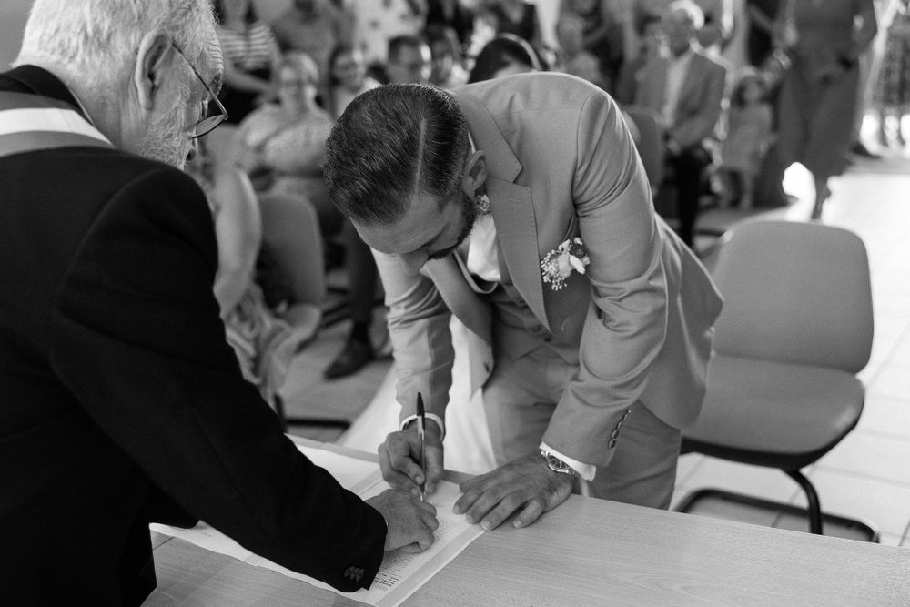 Wedding signing ceremony captured in monochrome with official and attendees.