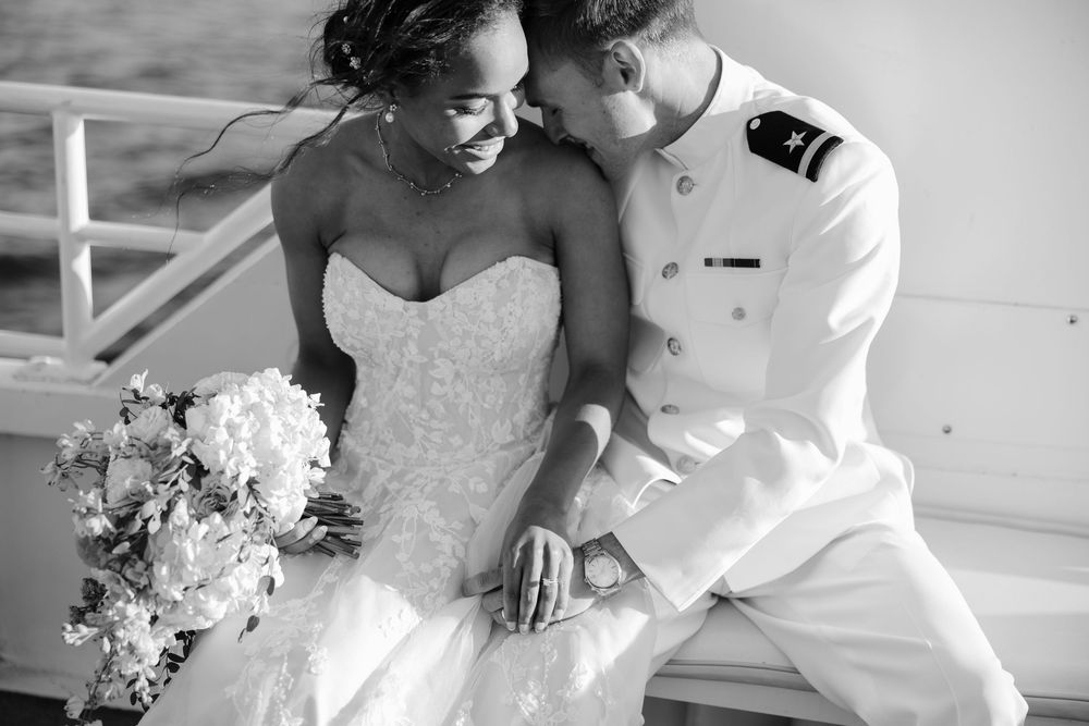A romantic black and white photograph of a happy newlywed couple sharing an intimate moment on their wedding day.