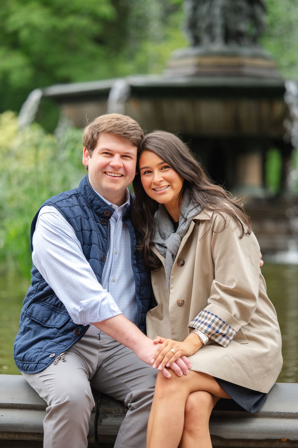 Couple shares romantic moments on a park bench surrounded by lush greenery at the Bethesda Fountain in Central Park by Joliette Marie Photo.