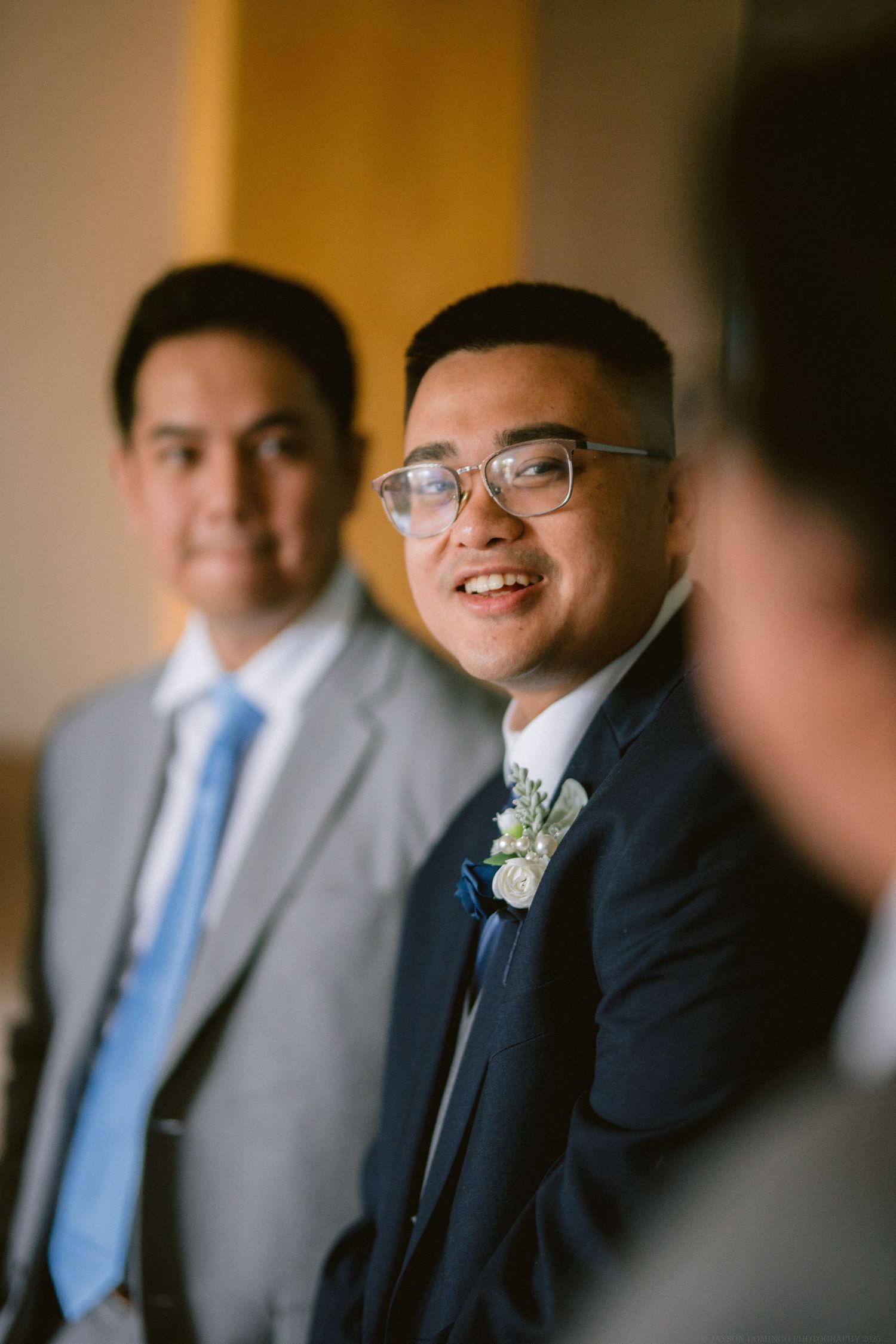 Two men in suits and ties smile during a formal event.