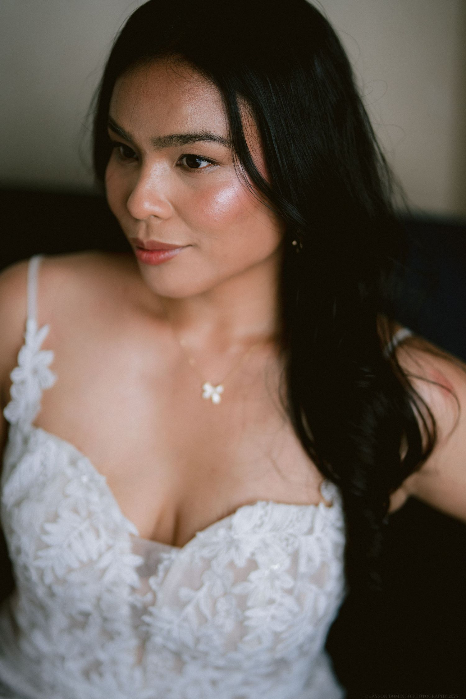 Close-up portrait showing intricate lace details of a wedding dress.
