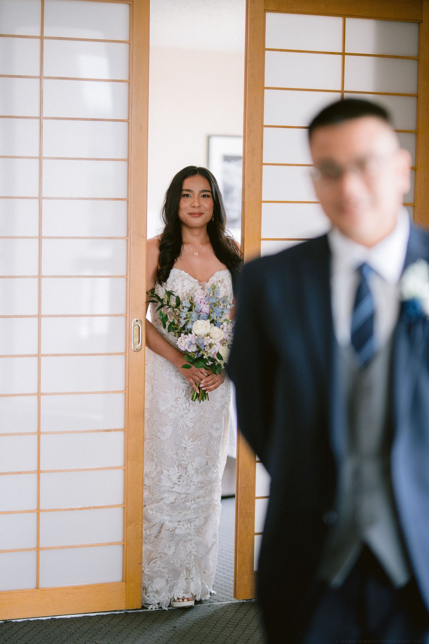 First look wedding moment with Japanese shoji screens and elegant bouquet.