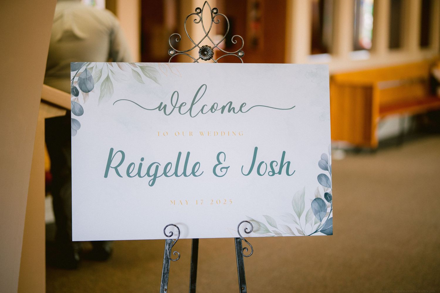 An elegant welcome sign for Raigelle & Josh decorated with blue floral designs.