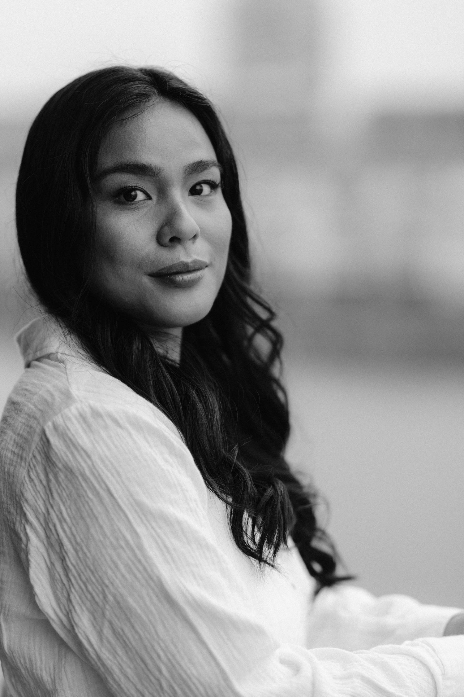 Black and white portrait of a woman in white clothing with long dark hair.