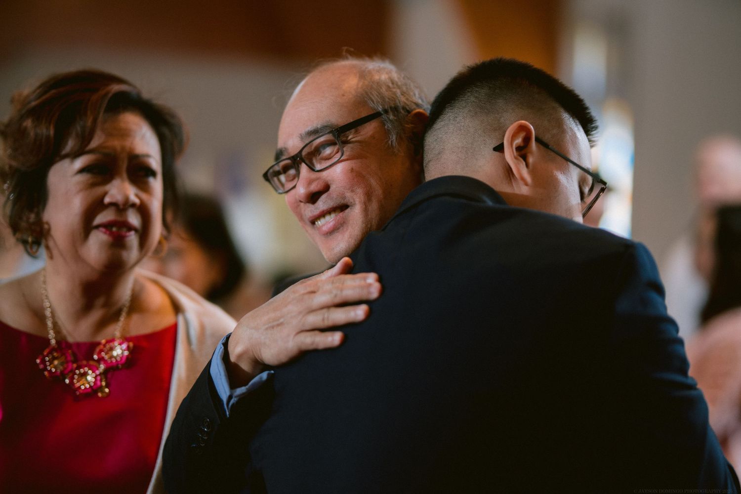 An emotional family embrace during a wedding celebration.