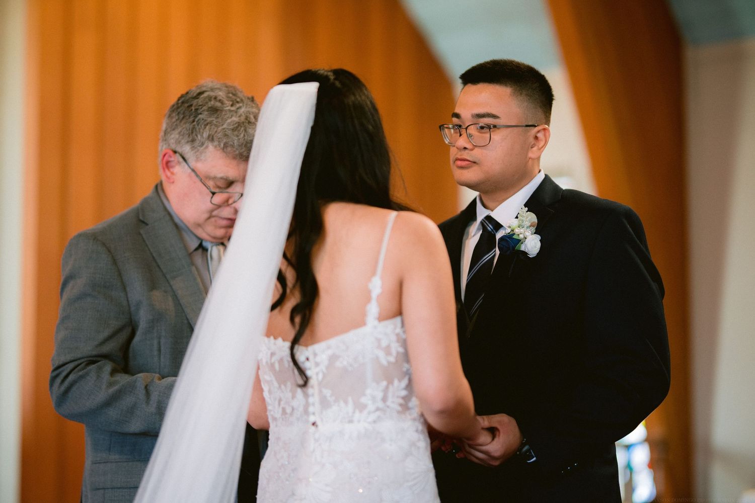 A wedding ceremony being conducted at the altar with the officiant performing the service.