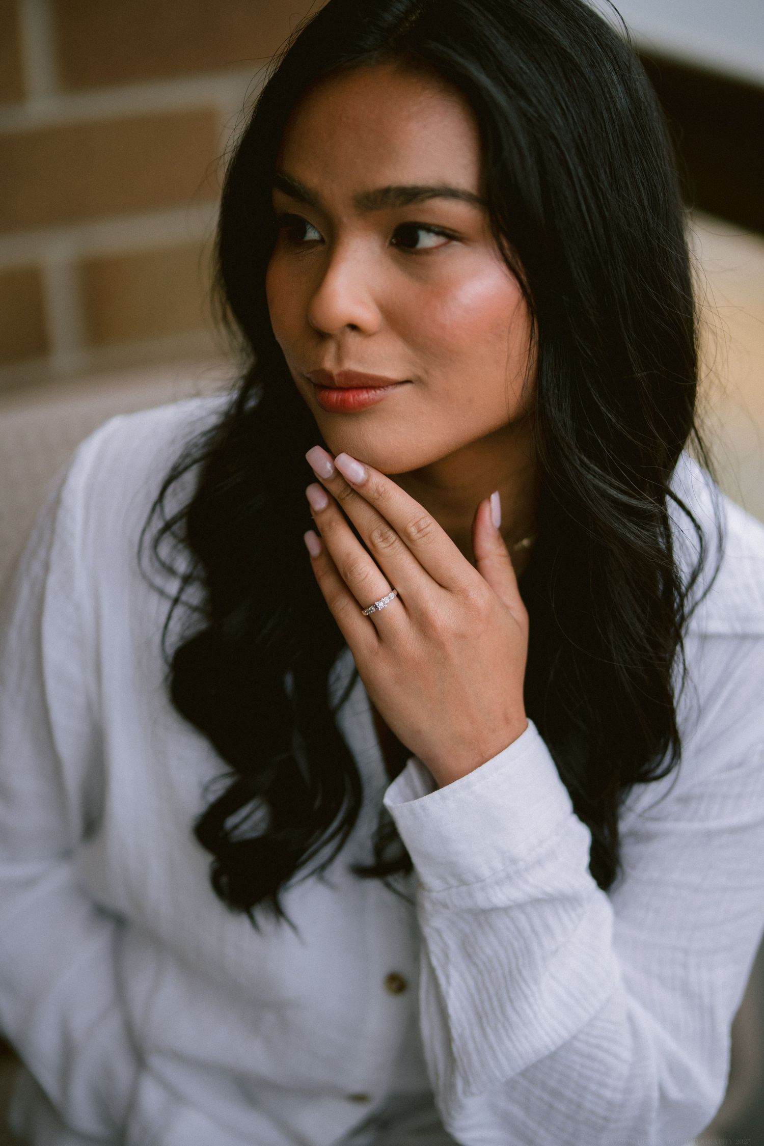 Portrait shot of a person in a crisp white shirt showing elegant jewelry.