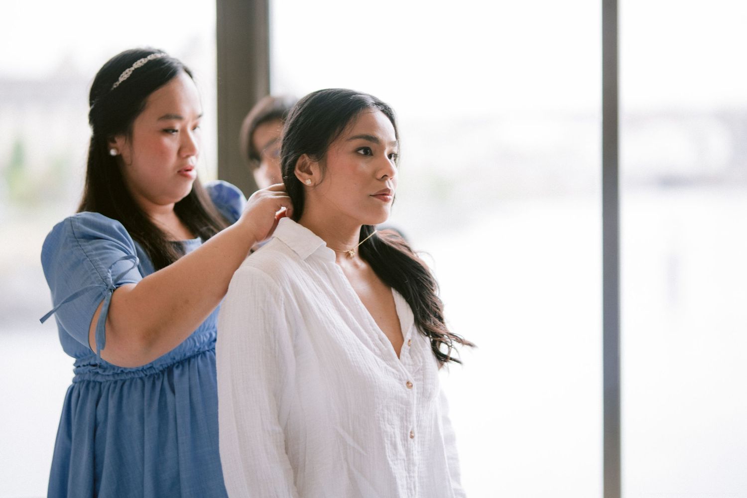 Hair stylist arranging bride's hair during wedding day preparations.