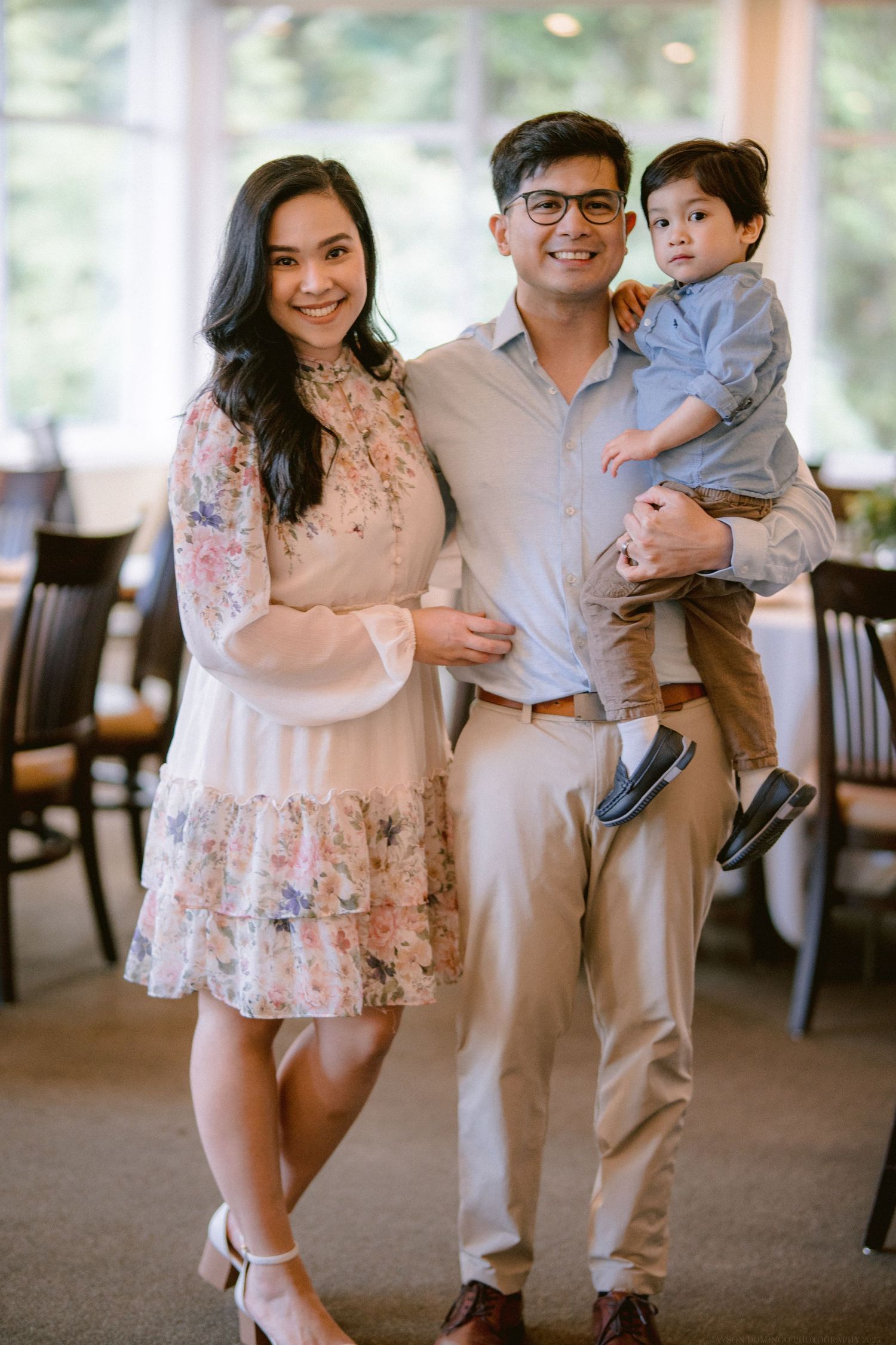 Happy family poses together in formal attire at an indoor venue.