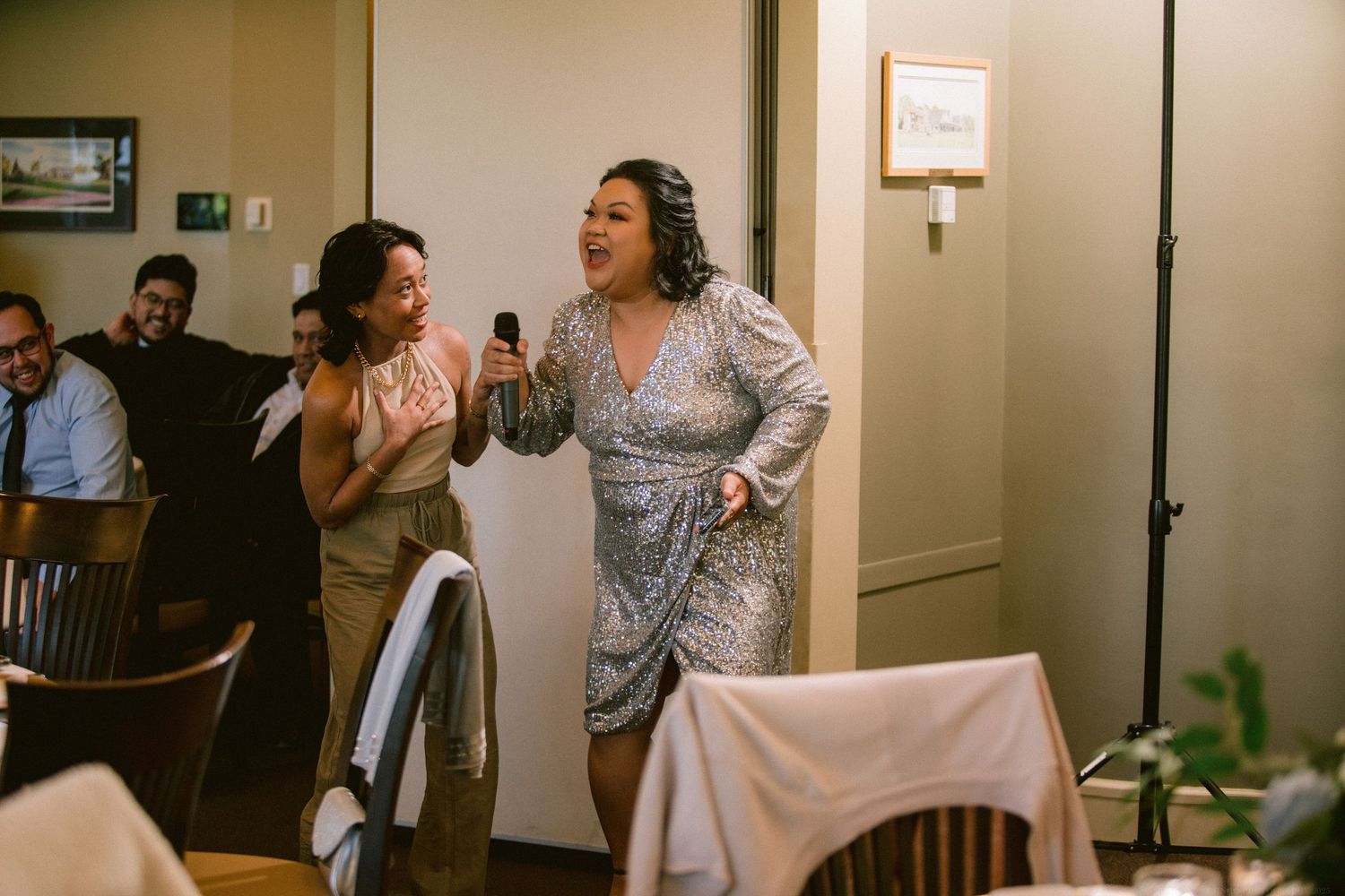 Wedding guests share an emotional, joyful moment during a reception celebration.