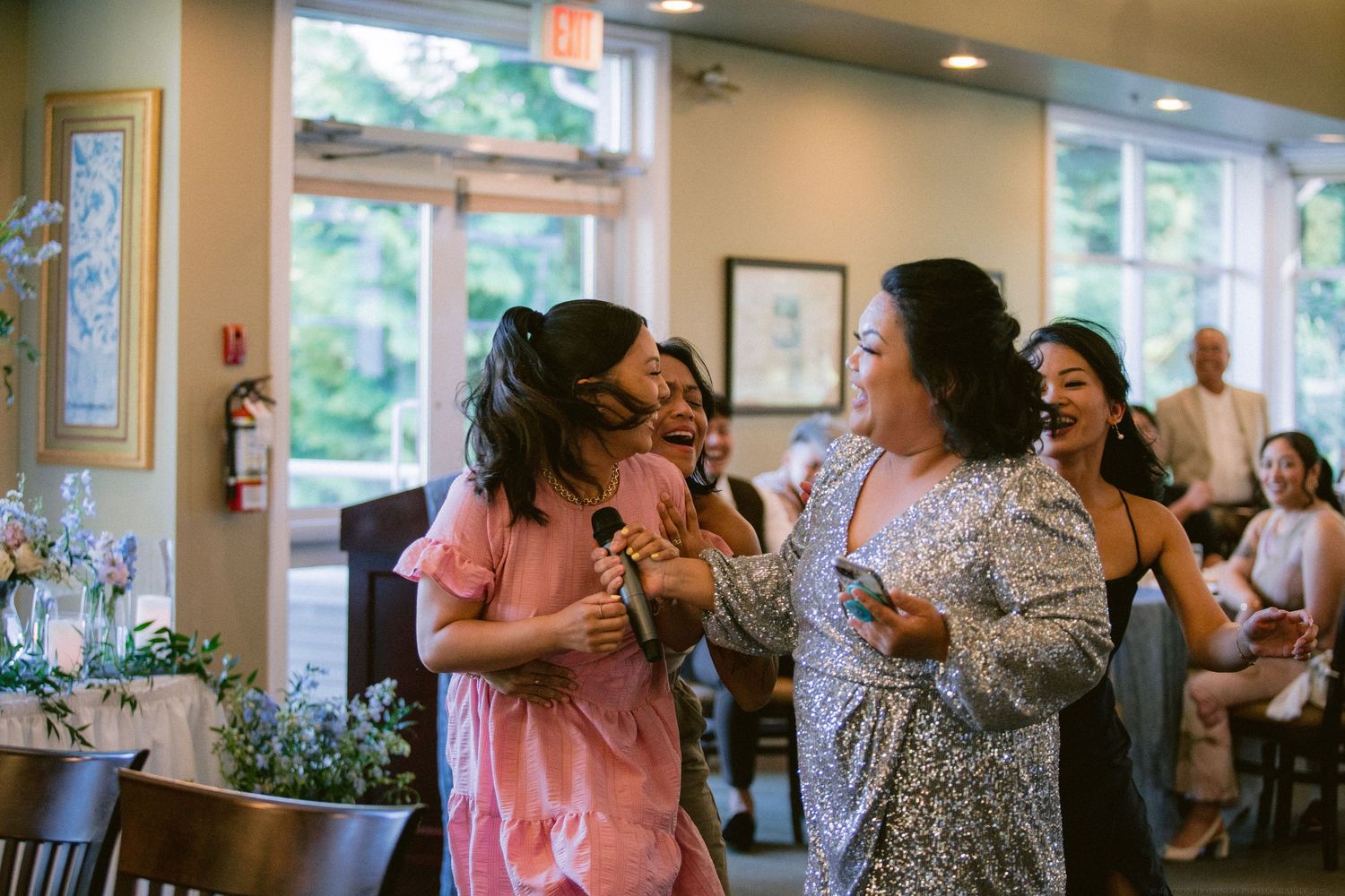 Wedding celebration filled with laughter and dancing in a bright indoor venue.