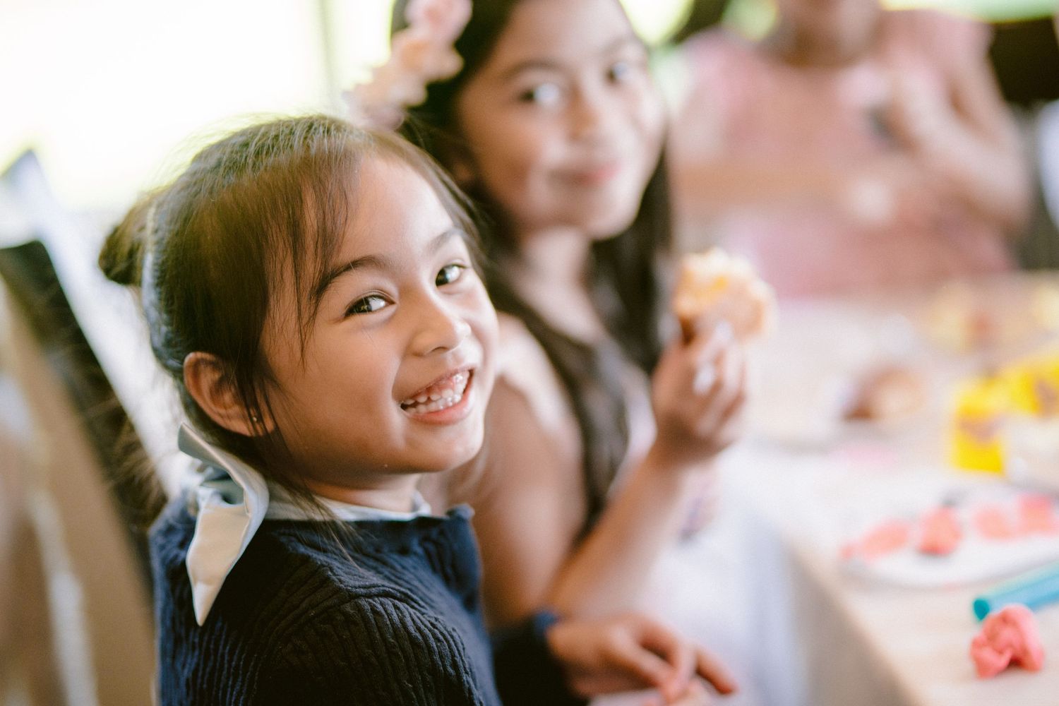 Young guest enjoying festivities at a celebratory event with joyful expression.