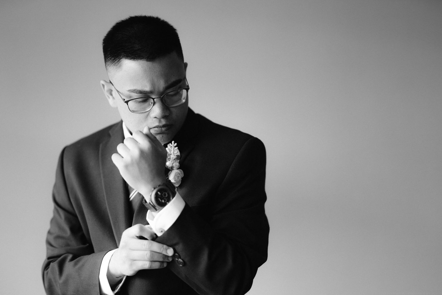 Professional black and white portrait against a simple gray background.