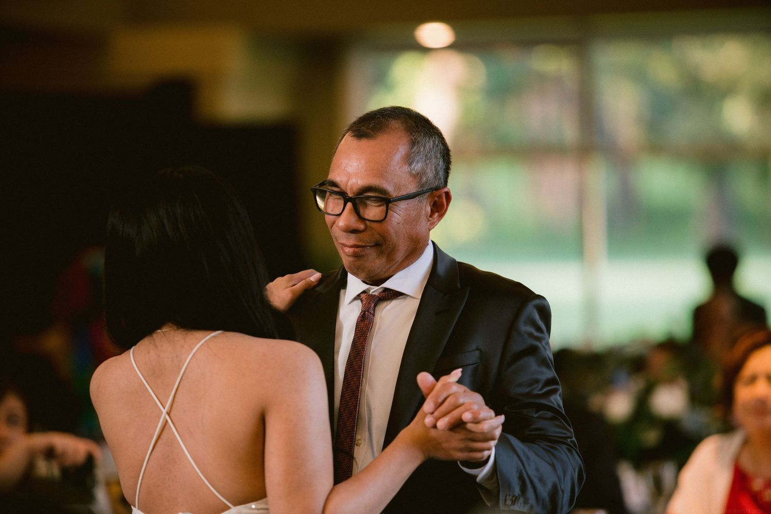 A couple shares an intimate dance at an elegant indoor wedding reception.