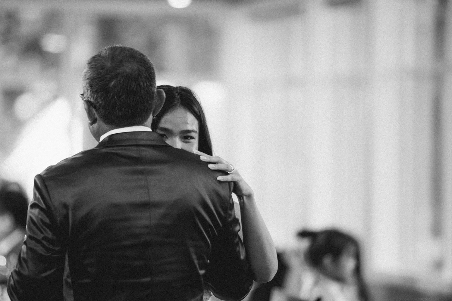 Intimate black and white photograph of couple dancing at formal event.