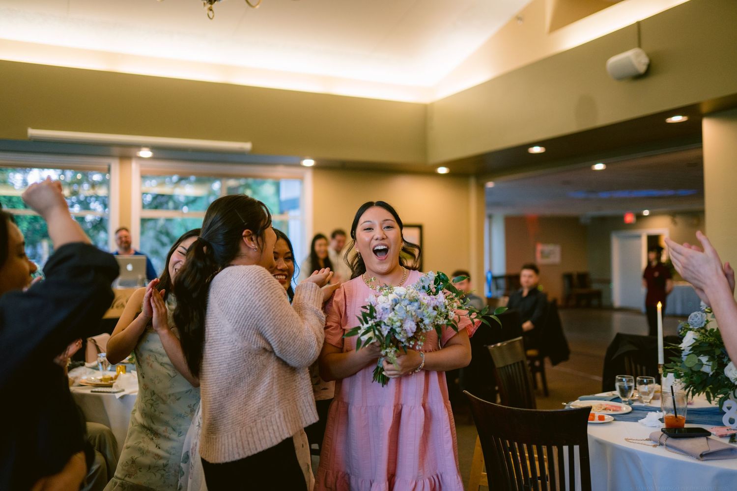 Lively celebration with guests dancing and celebrating at an indoor reception.