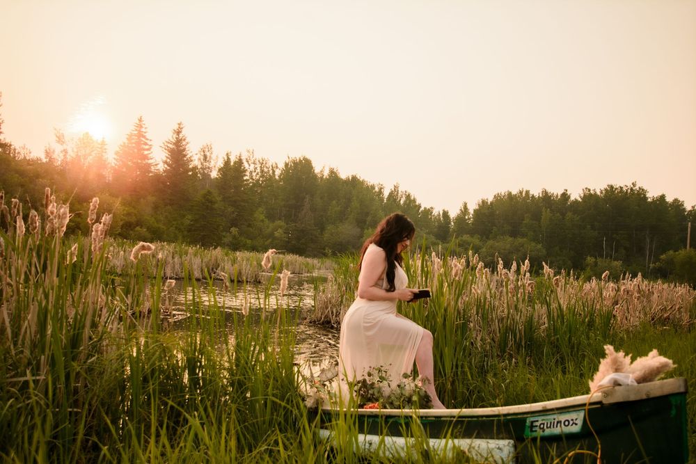 A misty golden sunset over a field with a couple sitting on a bench in silhouette.