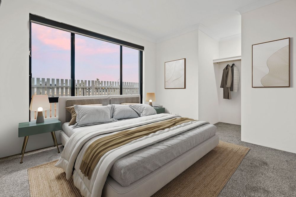Modern bedroom interior with floor-to-ceiling windows, gray bedding, and minimal decor in warm neutral tones.