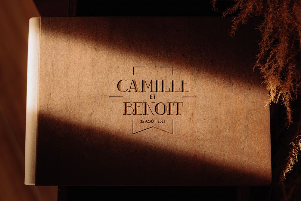 Wedding album cover with 'Camille & Benoit' text embossed in warm lighting.