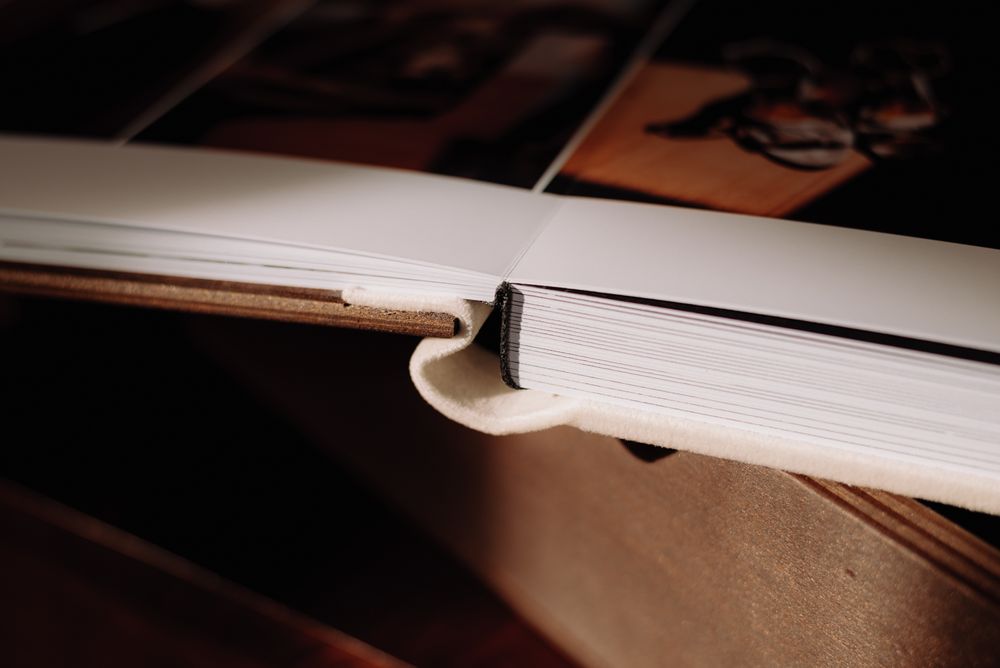 Macro shot of an open book binding showing white pages and stitching details.