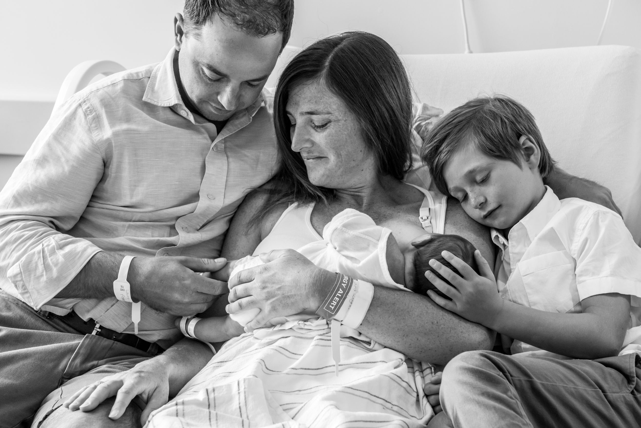 Family gazing at newborn captured in a Fresh 48 Session by Heidi Harting Photography