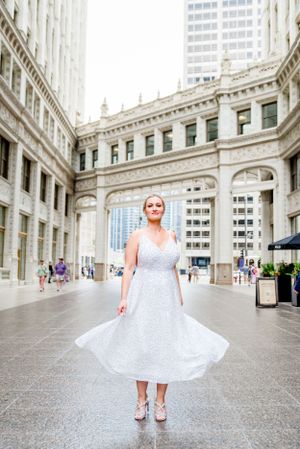 blonde woman twirling in silver sequin dress under Wrigley Building after downtown Chicago elopement