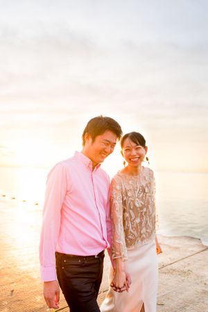 couple holding hands at walking along Lake Michigan at sunrise at Chicago Montrose Harbor